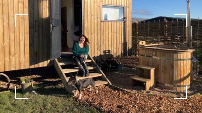 Susan Griffin sitting on the steps of a digital detox cabin in Leicester with sun shining