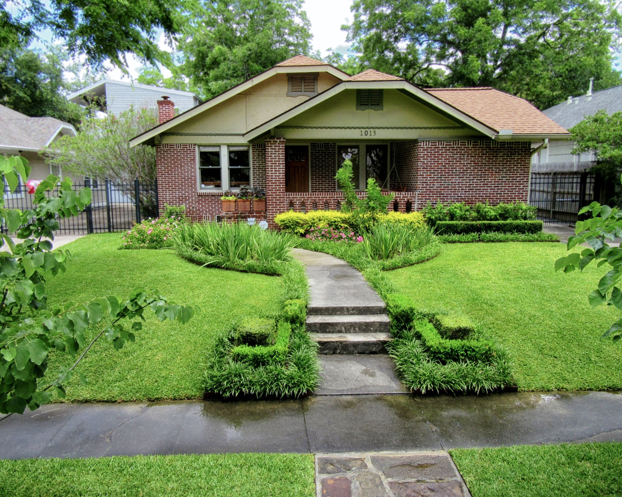 front yard with lush lawn and curved concrete path leading to front door
