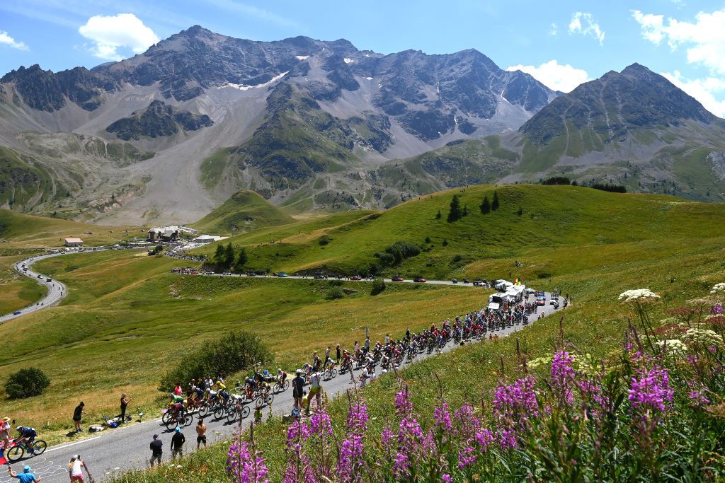 ALPE DHUEZ FRANCE JULY 14 A general view of Wout Van Aert of Belgium Green Points Jersey Jonas Vingegaard Rasmussen of Denmark and Team Jumbo Visma Yellow Leader Jersey and the peloton compete beginning to climb the Col du Galibier 2619m mountain landscape during the 109th Tour de France 2022 Stage 12 a 1651km stage from Brianon to LAlpe dHuez 1471m TDF2022 WorldTour on July 14 2022 in Alpe dHuez France Photo by Tim de WaeleGetty Images