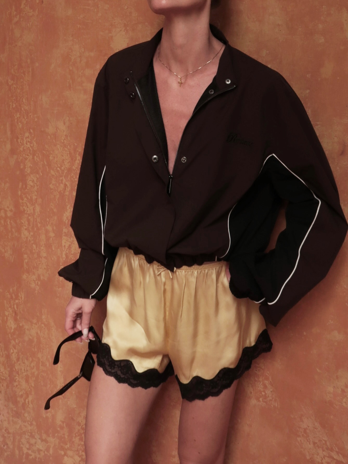 Influencer wearing satin lace-trim shorts.