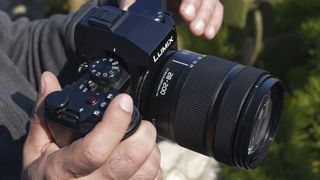 Panasonic LUMIX S 28-200mm F4-7.1 MACRO lens in the hand