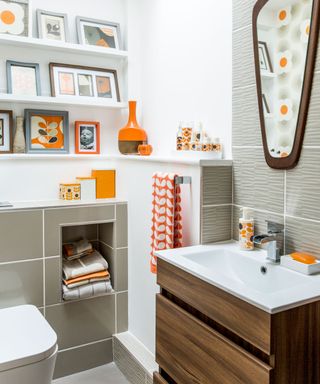 bathroom with table top washbasin and pictures on white shelf