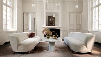 a living room with white couches designed by Gwyneth Paltrow for CB2