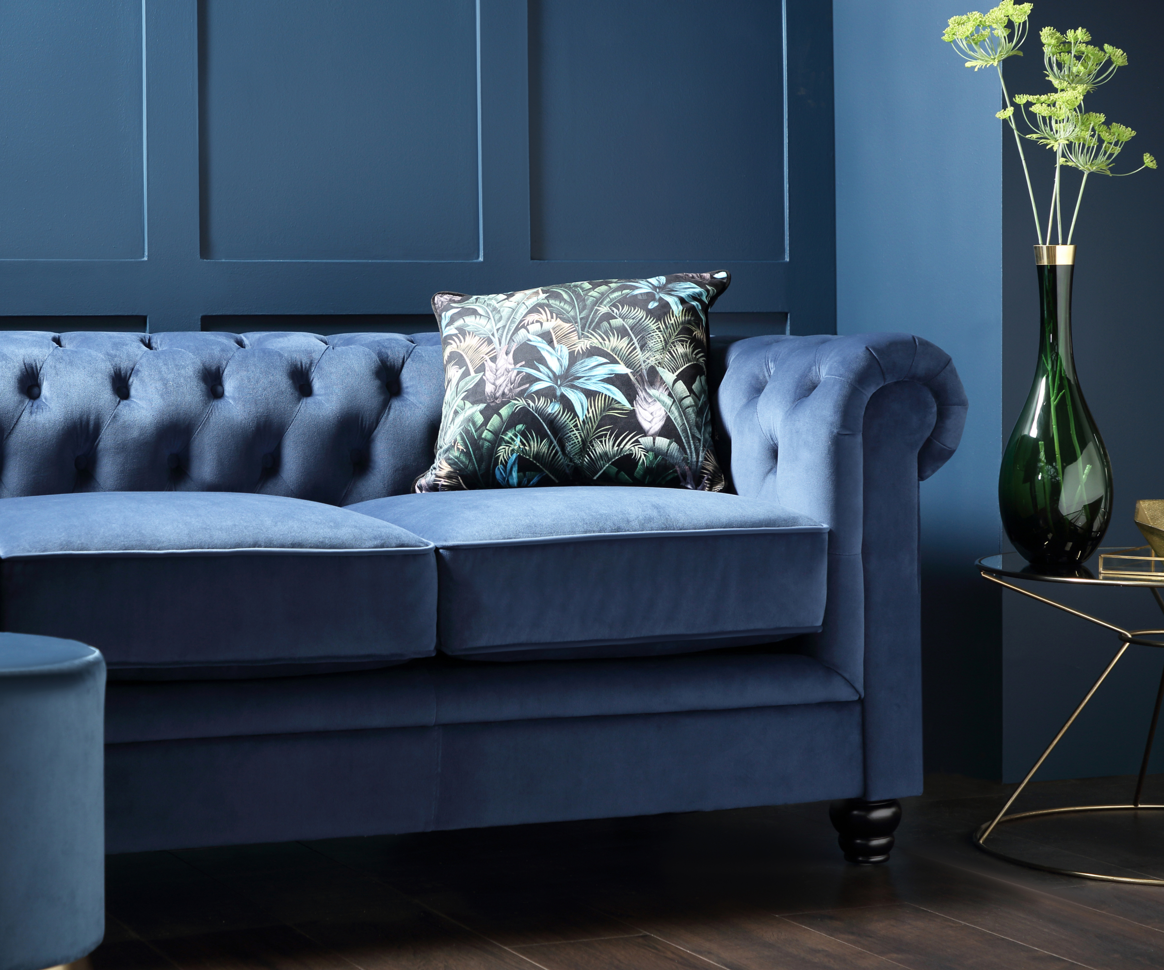 living rom with blue walls, blue sofa and metallic side table