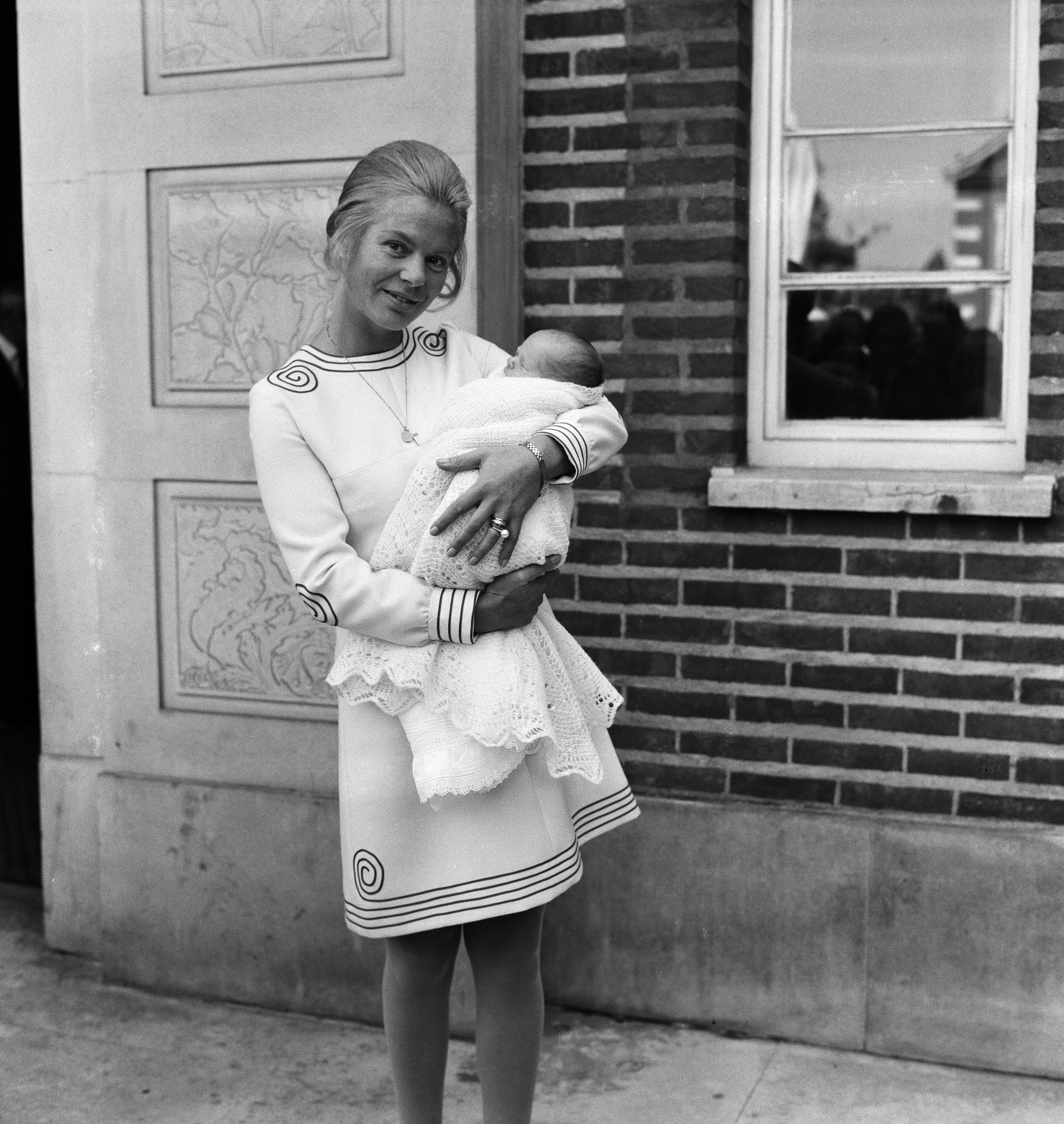 The duchess of Kent holding baby Lord Nicholas Windsor in front of a window