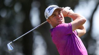 Justin Thomas holds a pose with an iron in his hands