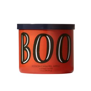 A black and orange candle jar that says 