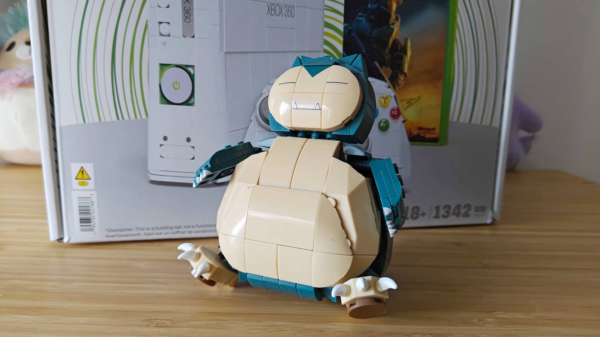 Snorlax está sentado frente a una caja MEGA Xbox 360