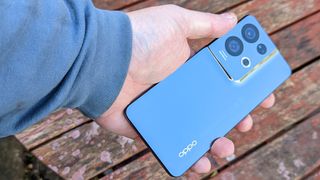 An Oppo Reno 8 Pro smartphone sitting on a rustic table