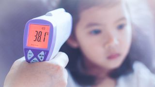 Pointing one of the best infrared thermometers at a small child