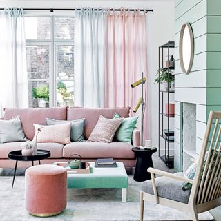 living area with glass window with curtains and pillows on pink sofa