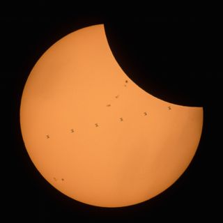 A composite image made from seven frames that shows the International Space Station transiting a partial eclipse of the sun.