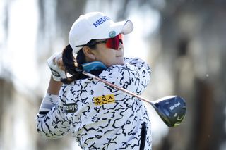 A Lim Kim hits a tee shot with a driver and watches its flight