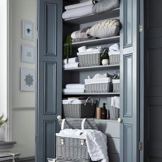 blue utility cupboard with storage baskets