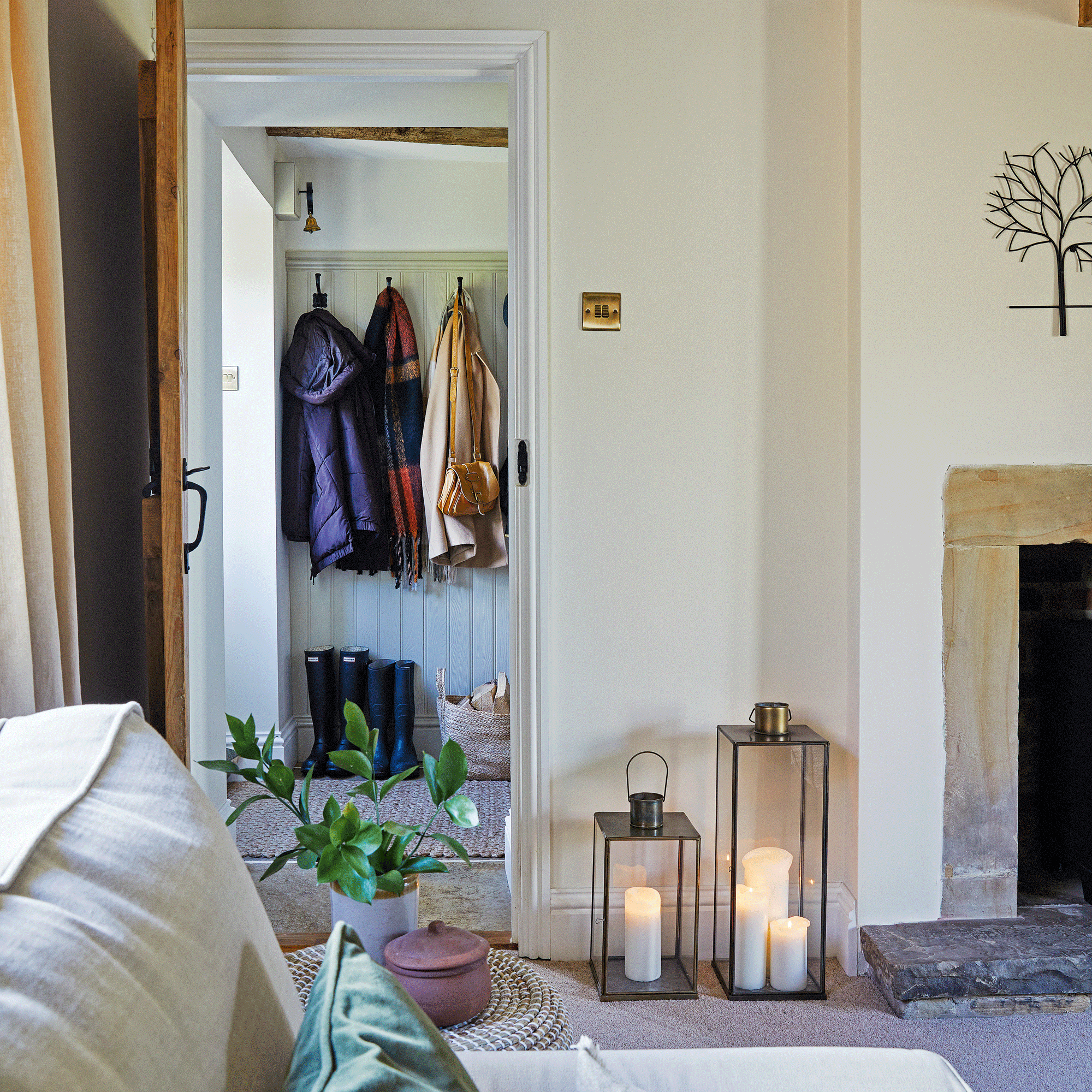 a living room with a view into a hallway with a coat rack
