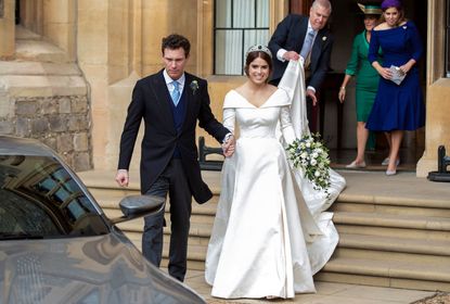  Princess Eugenie and Jack Brooksbank helped by Princess Beatrice and Prince Andrew, Duke of York leave Windsor Castle in an Aston Martin DB10 after their wedding