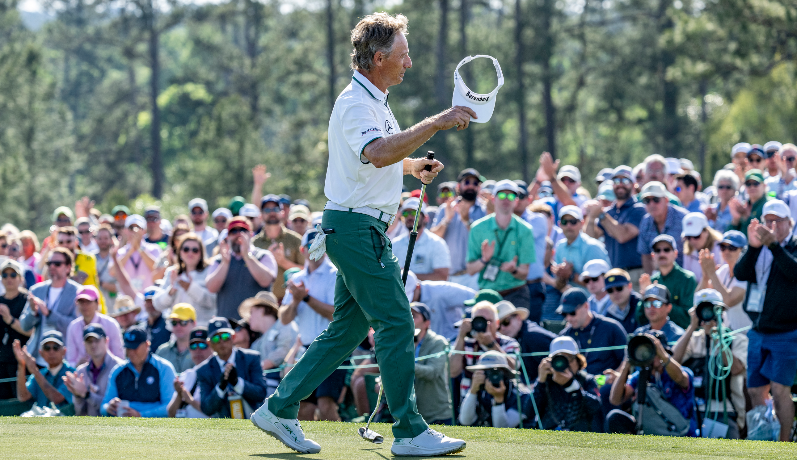 Bernhard Langer waves to the crowd as he walks off the 18th green
