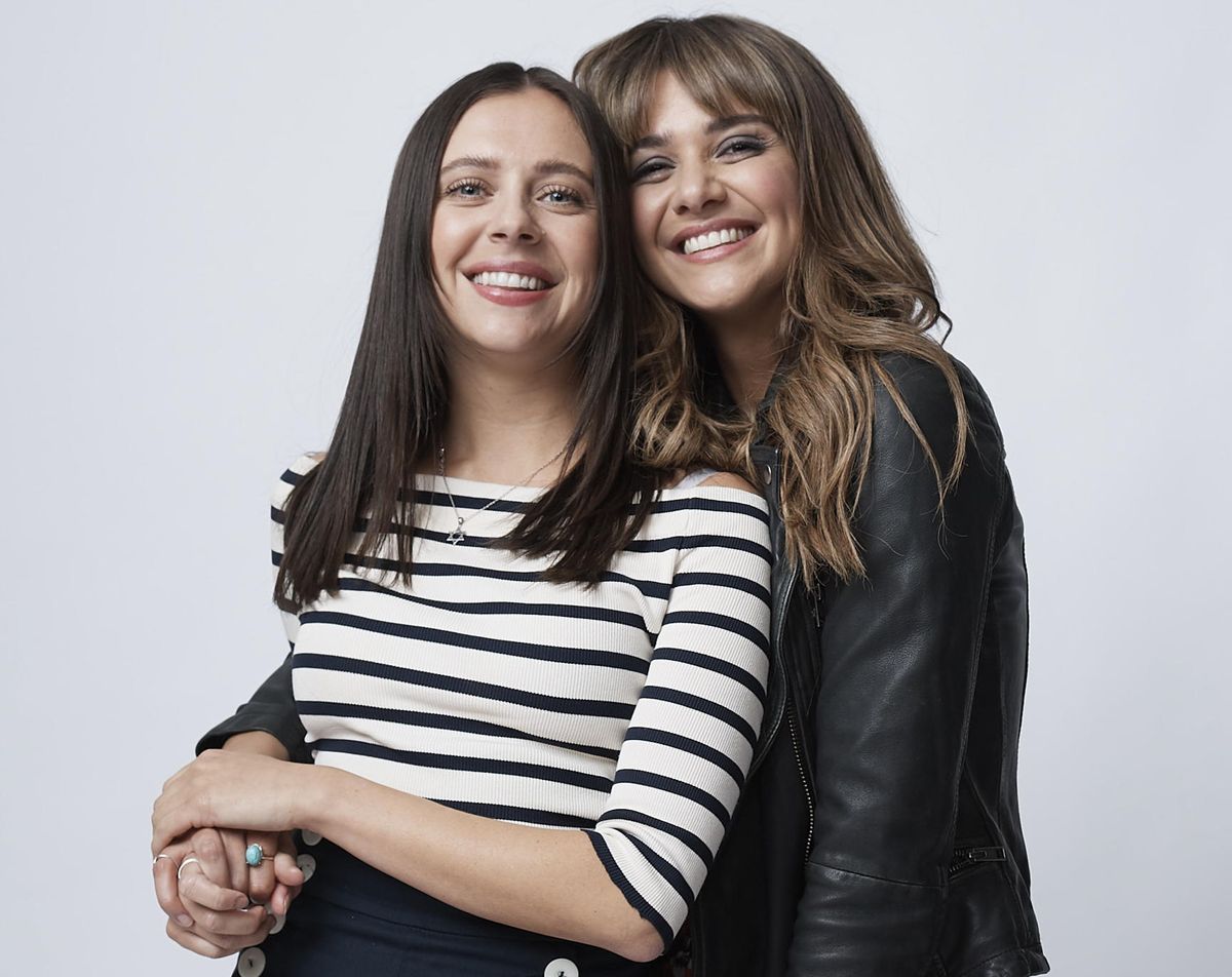 A studio shot of Bel Powley in a white and blue Breton top as Birdy, and Emma Appleton in a black leather jacket as Maggie. Maggie has her arm around Birdy&#039;s waist