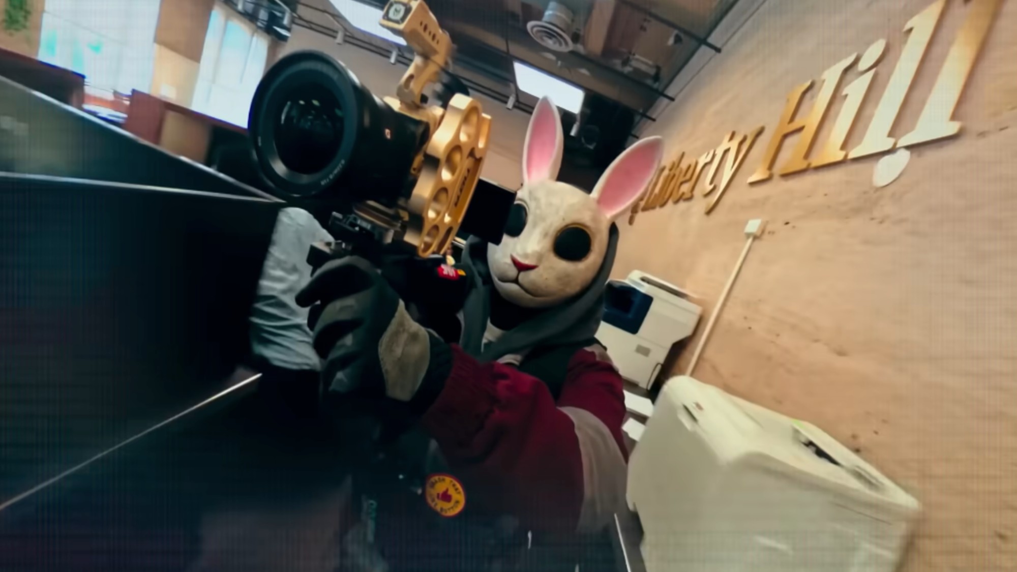 A man wearing a rabbot mask and pointing a camera at the camera