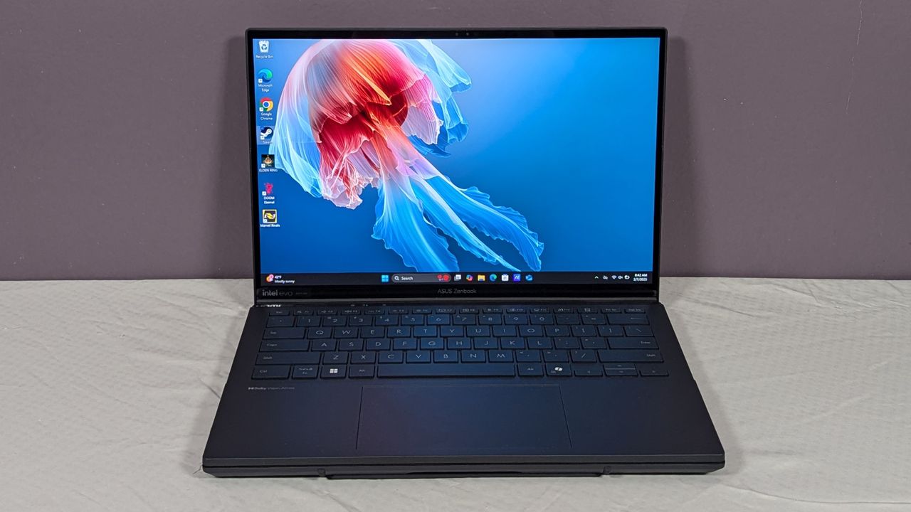 An open and powered on laptop on top of a white surface, showing a pink and transparent jellyfish underwater on the screen.