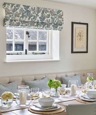 patterned blind in a dining area of open plan kitchen diner with banquette and blue cushions