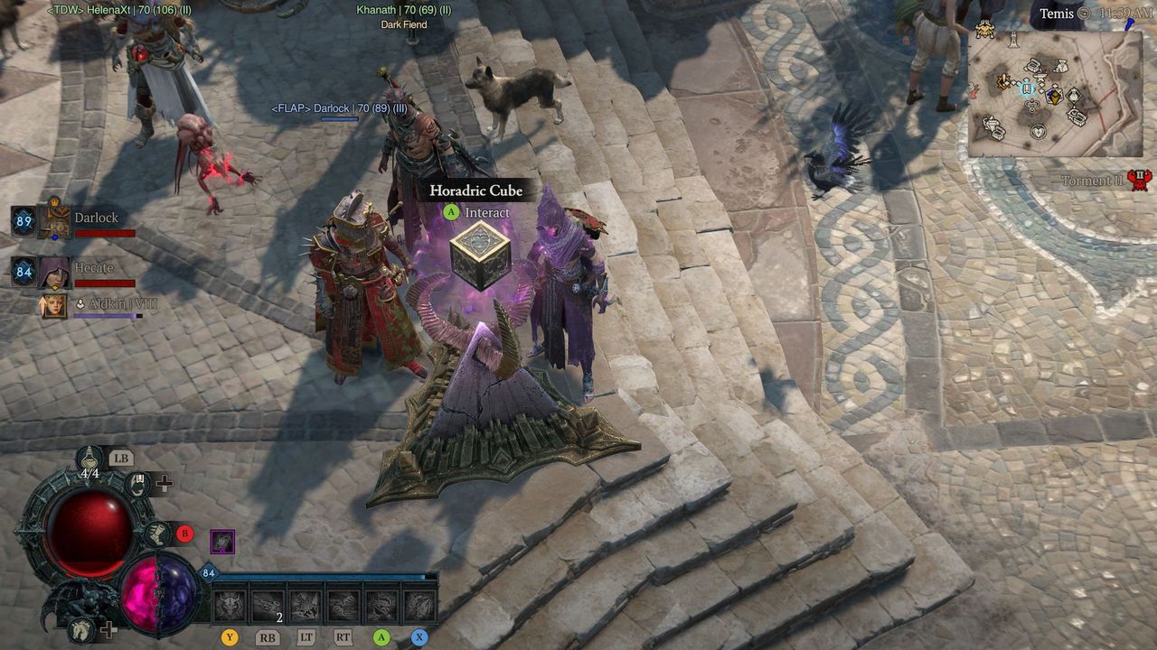 Video game scene showing characters standing on a cobblestone path around a glowing Horadric Cube.