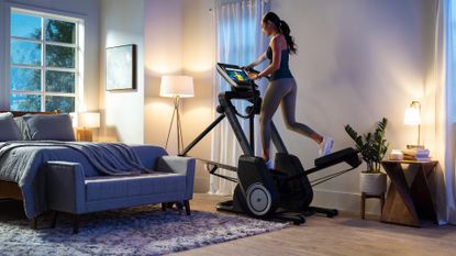 NordicTrack FS14i FreeStride Trainer review: Pictured here, an athletic woman using the exercise machine in a living room
