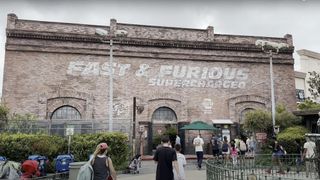 The painted outside of the Fast & Furious Supercharged ride at Universal Orlando with people swarming in. 