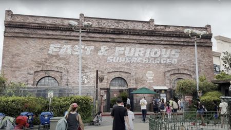 The painted outside of the Fast & Furious Supercharged ride at Universal Orlando with people swarming in. 
