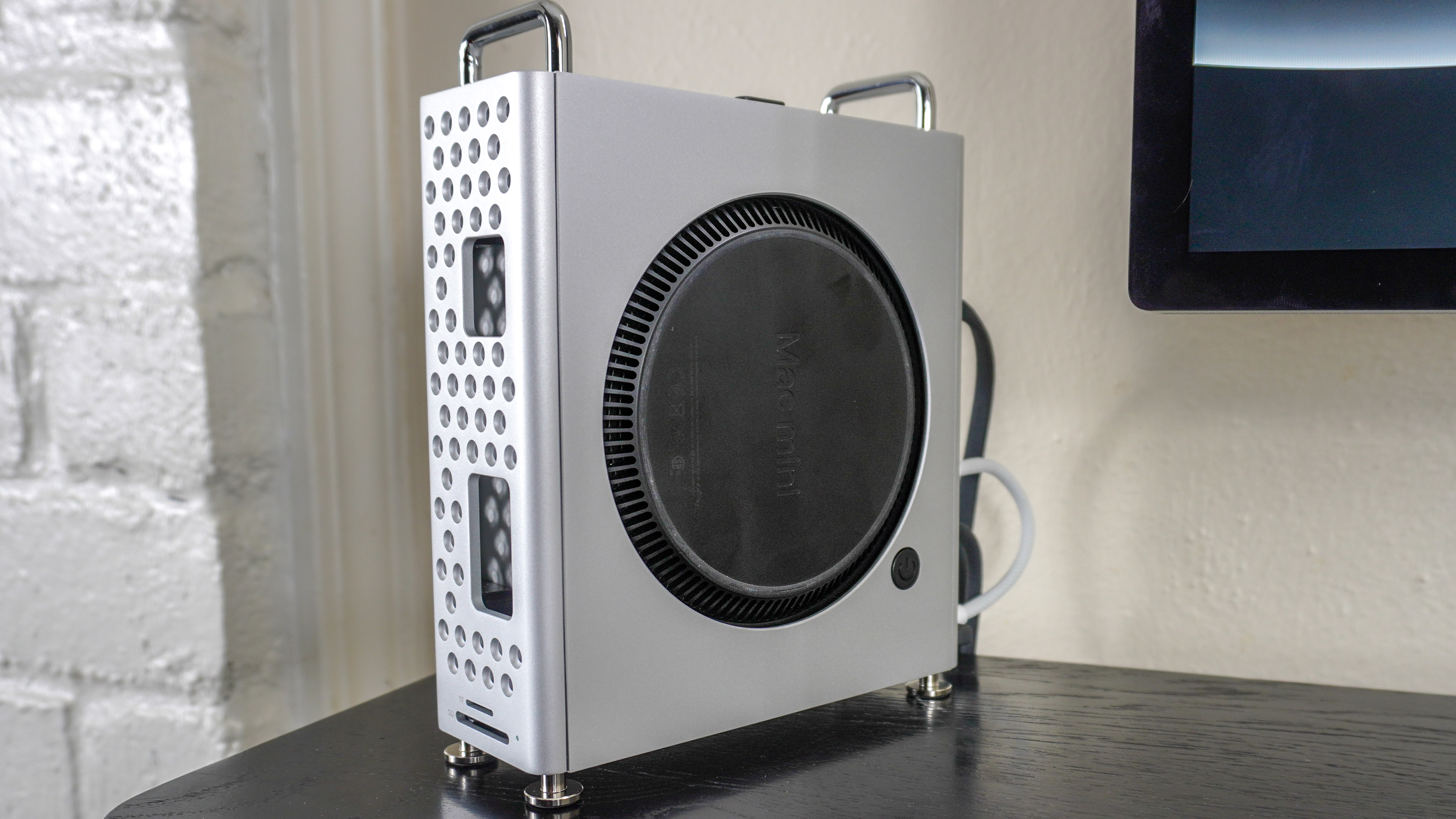 A Mac mini M4 inside the Orico MiniPro Dock Case on top of a desk shelf
