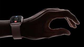 En Apple Watch Series 9 gesture runt en handled i mörkret.