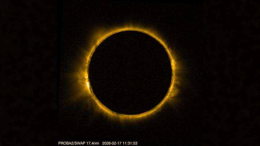 detailed view of the sun blocked by the moon in the center, creating a dramatic ring of fire against a black background. The sun's corona is visible around the edge of the moon. 