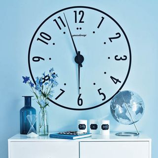 blue wall with large clock and book
