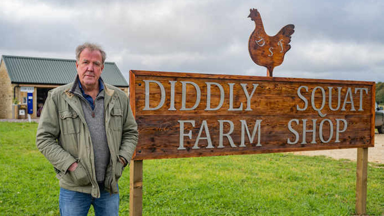 Jeremy Clarkson stands by a sign in Clarkson's Farm