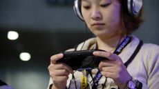 Young woman playing a PS Vita at Tokyo Game Show in 2015