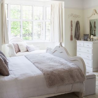 bedroom with white window and bed