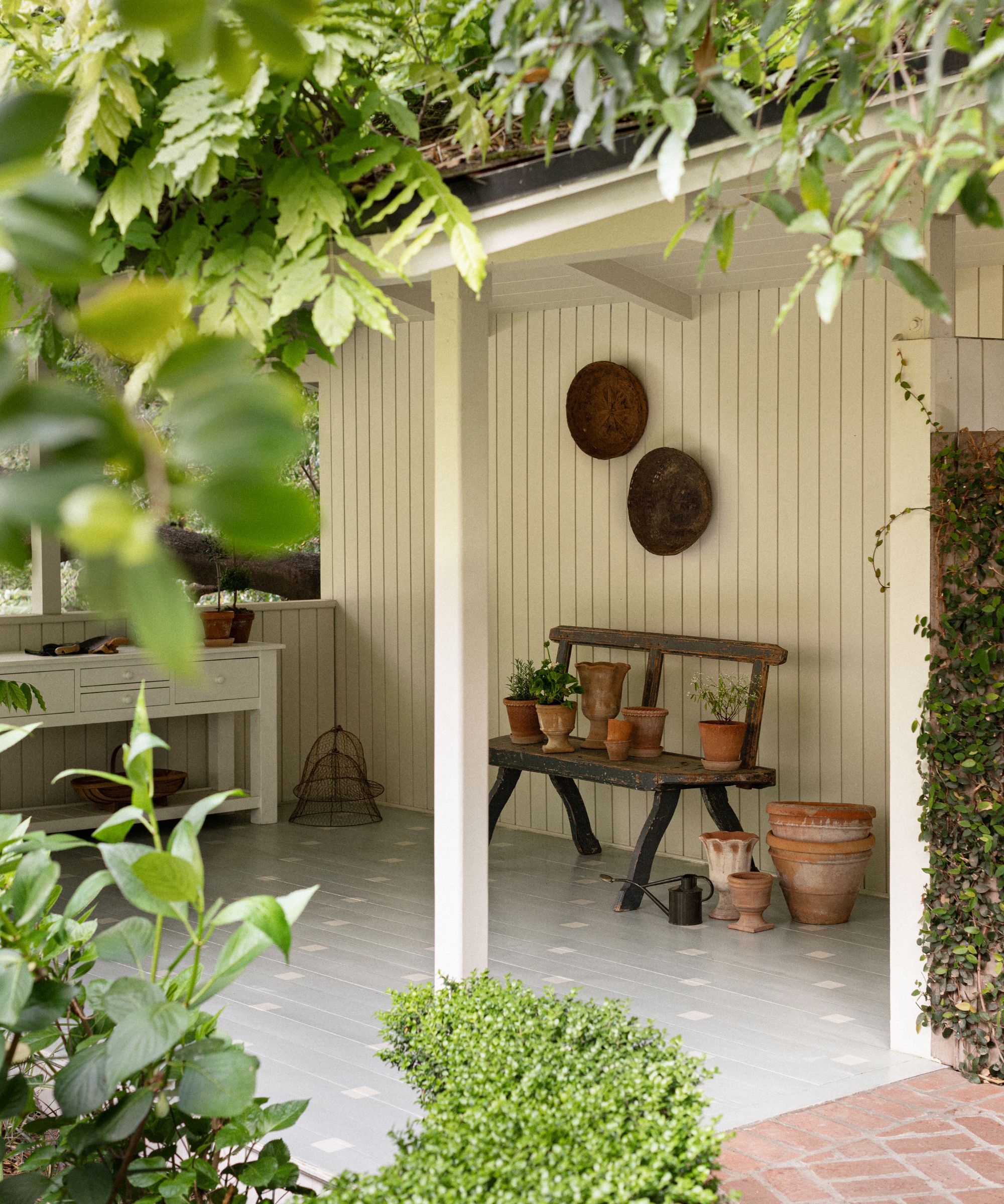 a small tea house in the garden of a property with neutral cladding