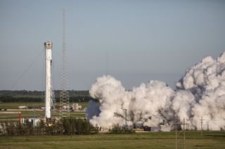 The center core of a SpaceX Falcon Heavy rocket undergoes a static fire test at the company's Texas facility in late April 2019, to prepare for the June launch of the STP-2 mission.