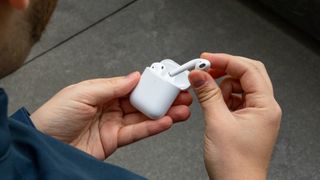 The AirPods being taken out of their charging case