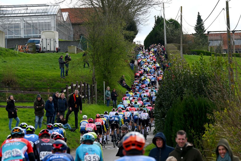 WEVELGEM BELGIUM MARCH 24 A general view of the peloton passing through Baneberg sector while fans cheer during the 86th GentWevelgem in Flanders Fields 2024 Mens Elite a 2531km one day race from Ieper to Wevelgem UCIWT on March 24 2024 in Wevelgem Belgium Photo by Tim de WaeleGetty Images
