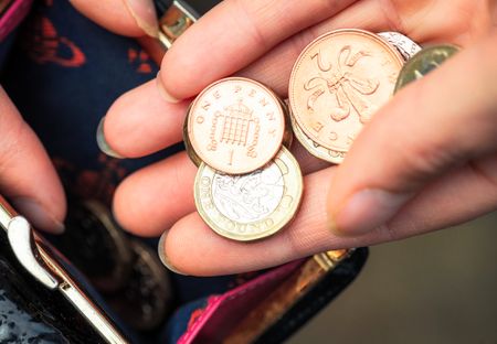 A picture of somebody holding a selection of coins in their hand.