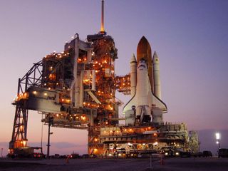 Amid the lights from the fixed and rotating service structures, space shuttle Discovery rests on the hardstand of Launch Pad 39B at NASA's Kennedy Space Center in Florida after completing the 4.2-mile journey from the Vehicle Assembly Building. The rollo