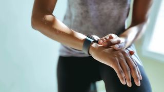 Woman checking fitness watch while doing cycling as a workout
