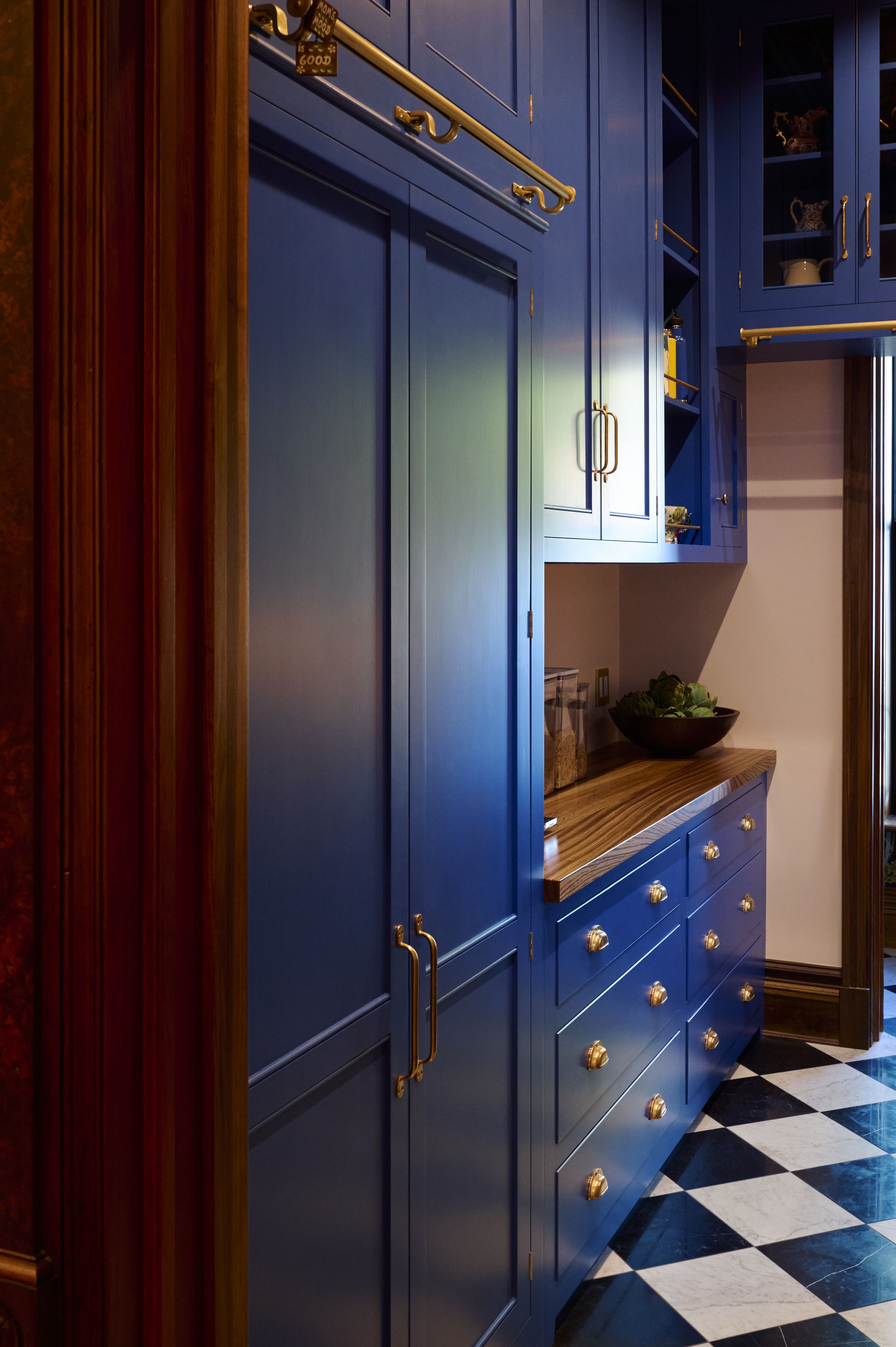 Two kitchens with black&amp; white chequerboard flooring, and saturated blue cabinets 