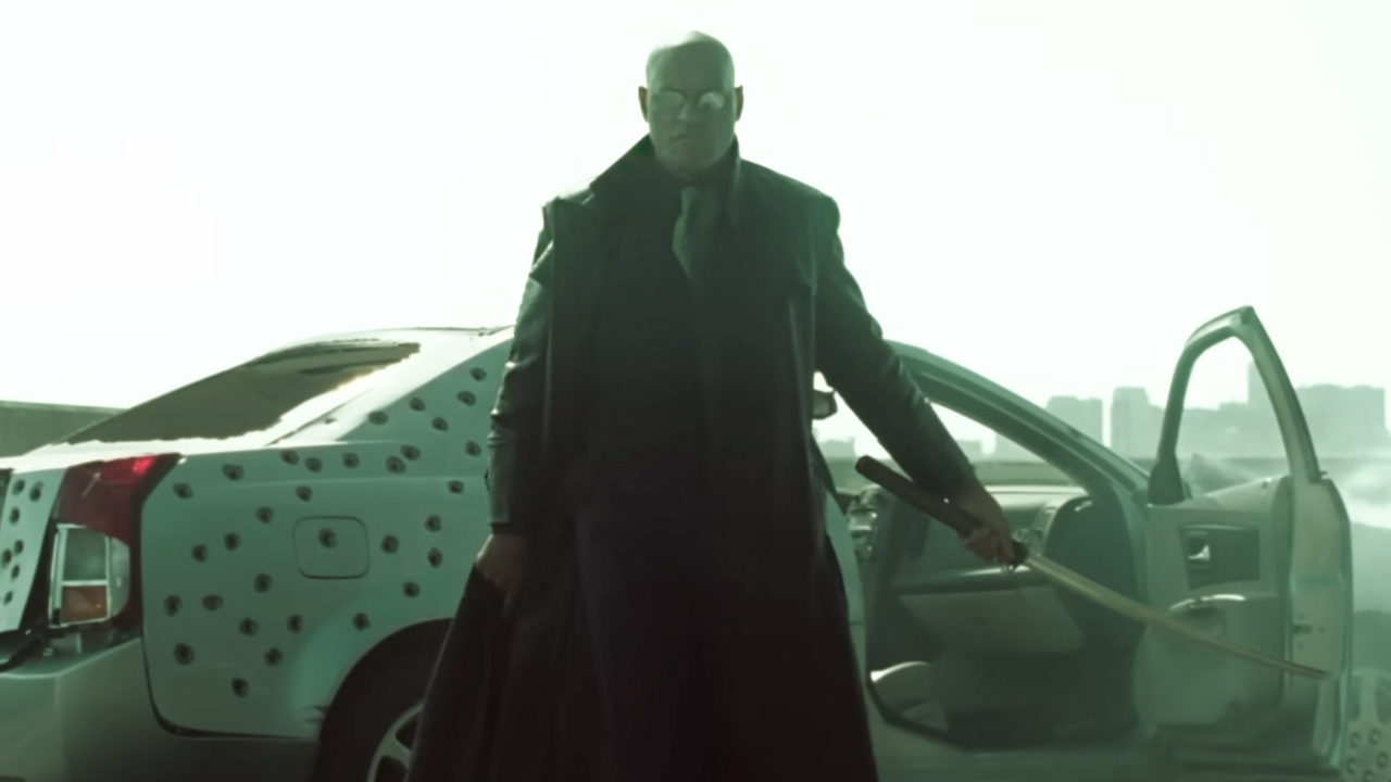 Laurence Fishburne as Morpheus standing with his sword reading for battle in The Matrix Reloaded.