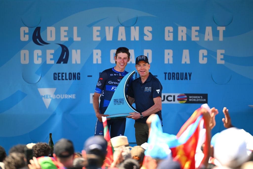 Laurence Pithie of New Zealand (Groupama-FDJ) receives the trophy as race winner of Cadel Evans Great Ocean Road Race for elite men directly from for pro Cadel Evans of Australia