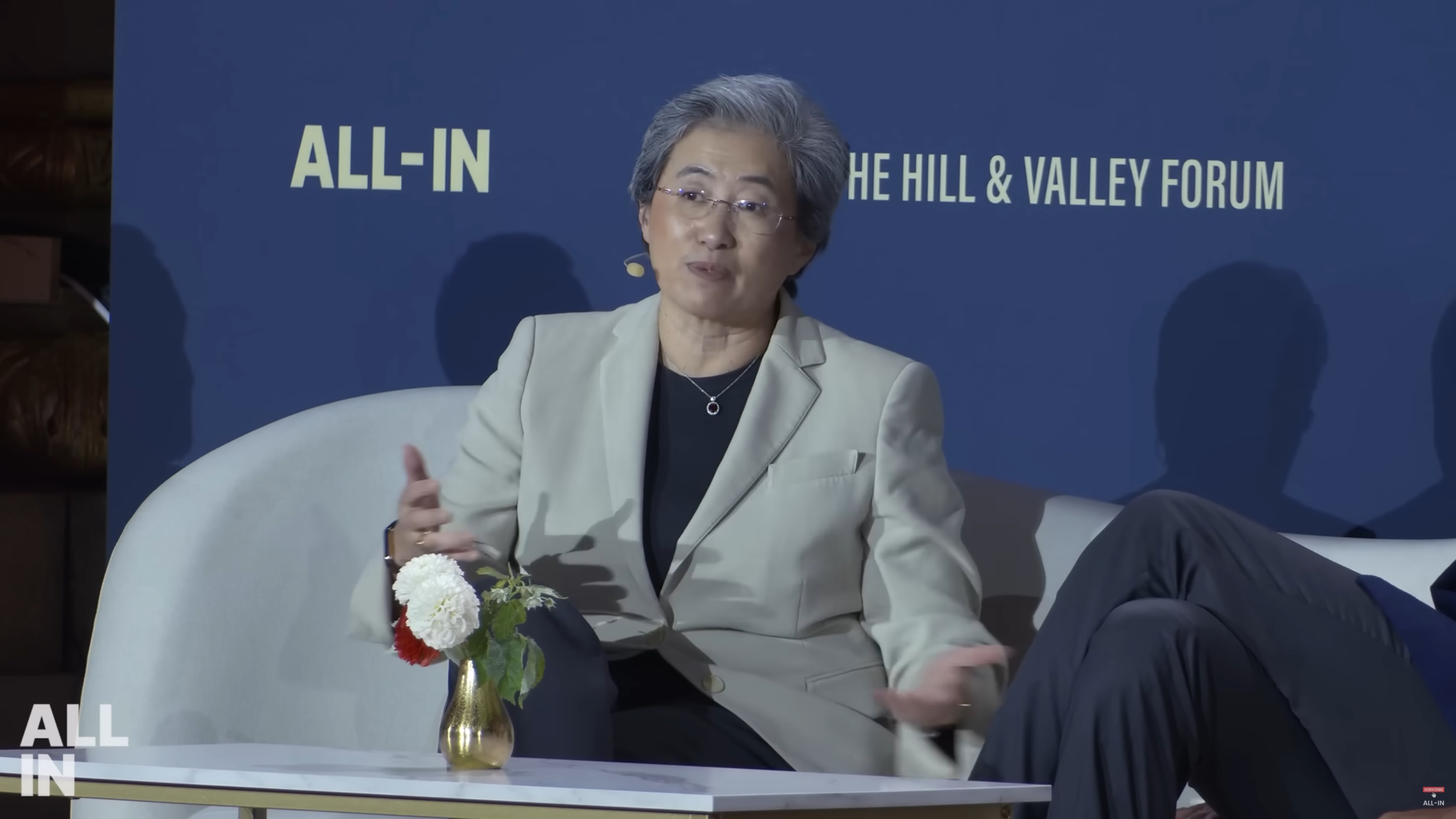AMD CEO Dr. Lisa Su talking at the All-In AI summit, gesticulating with her hands 