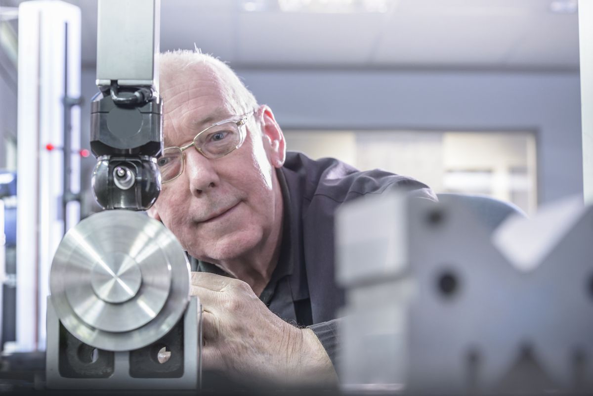 Engineer using tool to measure components in engineering factory 