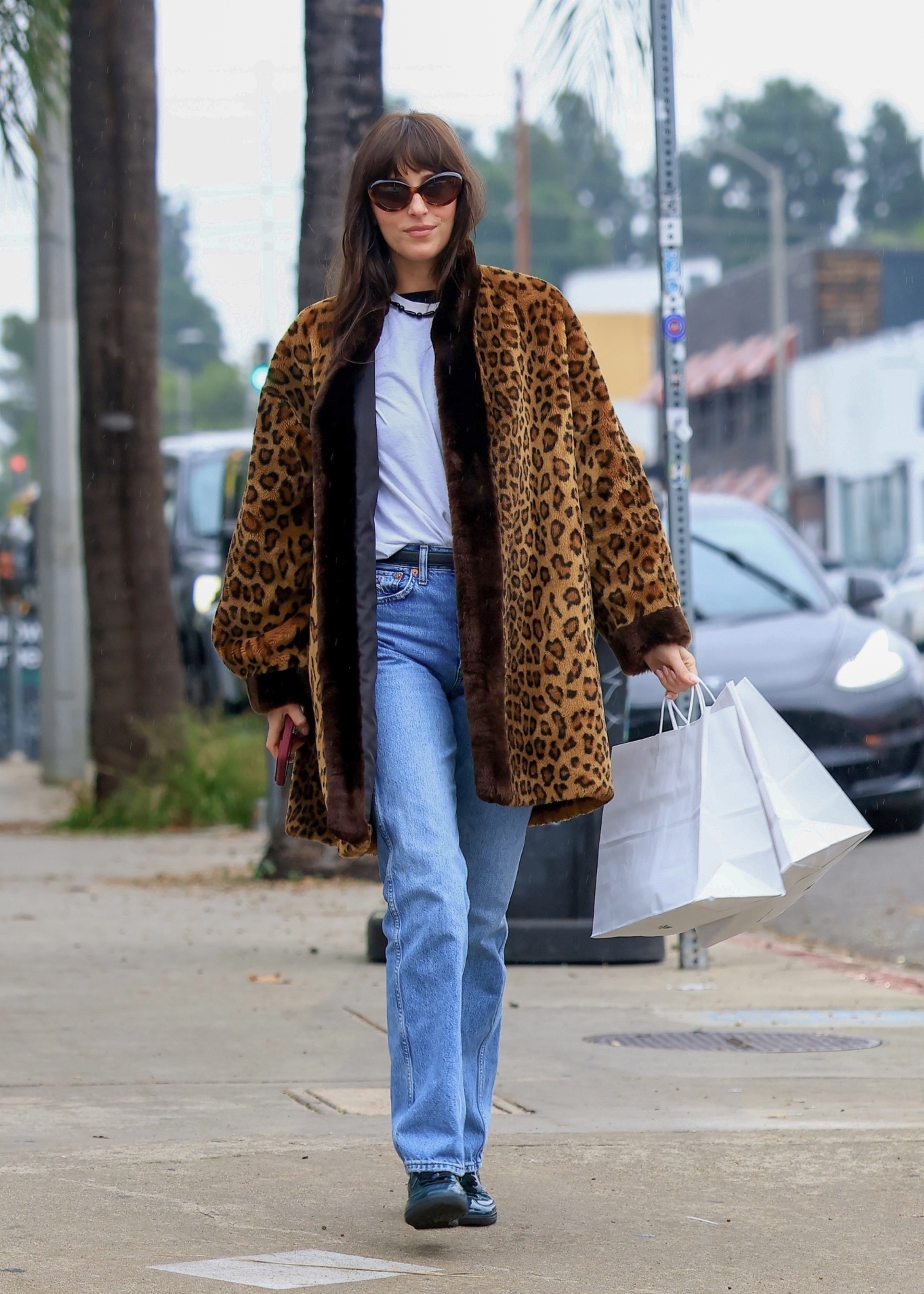 An image of Dakota Johnson wearing patent leather trainers.