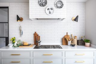 A white modern kitchen with brass cabinet hardware